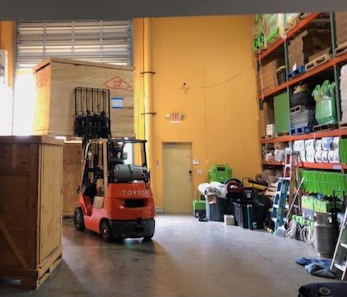 SERVPRO warehouse with green equipment on shelves and contents in wood crates